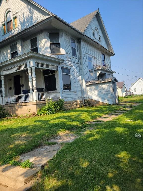 606 Meridian St, Tipton, IA 52772 - view of home's exterior featuring a porch and a lawn