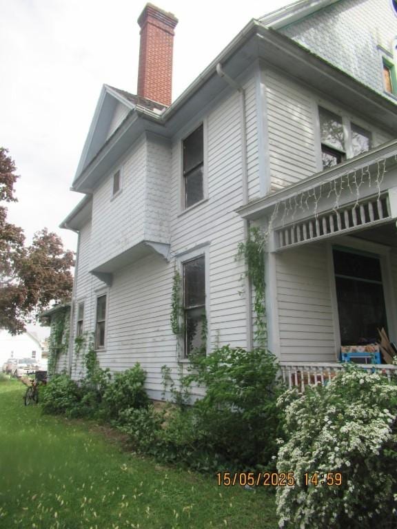 606 Meridian St, Tipton, IA 52772 - view of side of property with a chimney and a yard