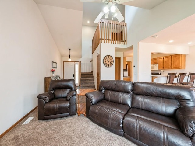 2635 6th St, Marion, IA 52302 - living room featuring stairs, light colored carpet, a ceiling fan, and high vaulted ceiling