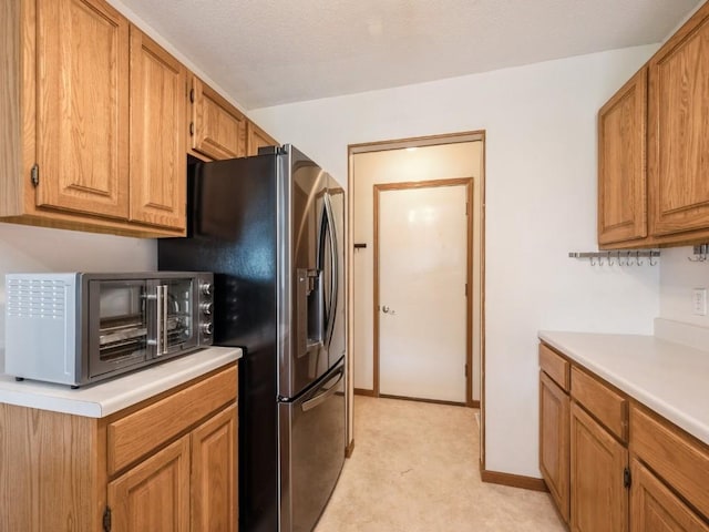 2635 6th St, Marion, IA 52302 - kitchen featuring light countertops, brown cabinets, light colored carpet, and stainless steel fridge with ice dispenser
