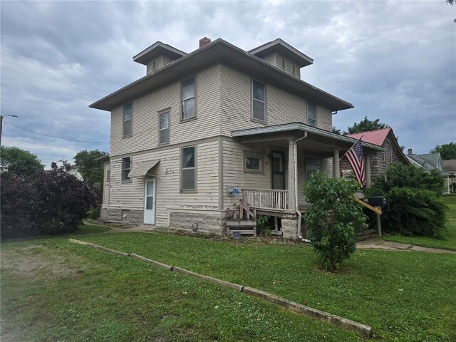 708 E 4th St, Vinton, IA 52349 - back of property with covered porch, a lawn, and a chimney