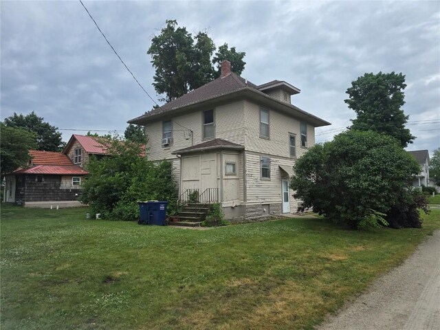 708 E 4th St, Vinton, IA 52349 - back of property with a lawn and a chimney