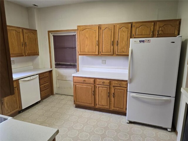 708 E 4th St, Vinton, IA 52349 - kitchen featuring white appliances, brown cabinetry, and light countertops