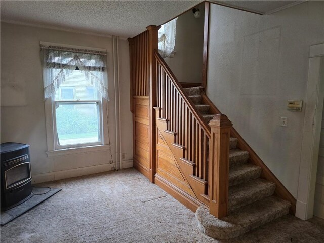 708 E 4th St, Vinton, IA 52349 - stairs with a wood stove, carpet flooring, and a textured ceiling