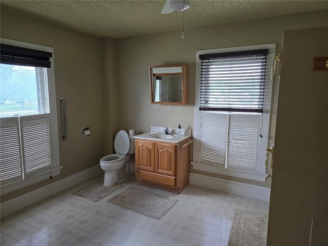 708 E 4th St, Vinton, IA 52349 - bathroom with vanity, tile patterned floors, a textured ceiling, and ceiling fan