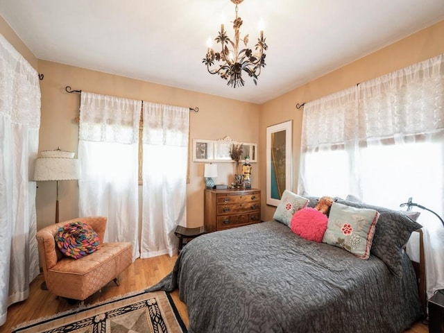 4288 Fox Meadow Dr SE, Cedar Rapids, IA 52403 - bedroom with multiple windows, a chandelier, and wood finished floors