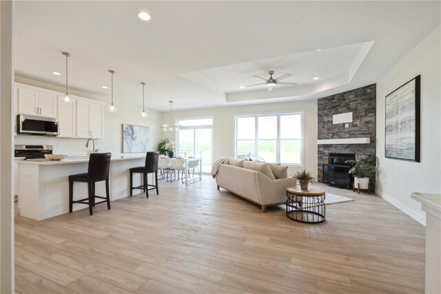 1417 Echo Ridge Ln, Marion, IA 52302 - living area with a ceiling fan, light wood finished floors, a tray ceiling, recessed lighting, and a fireplace
