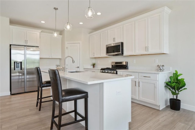 1417 Echo Ridge Ln, Marion, IA 52302 - kitchen featuring appliances with stainless steel finishes, light wood-style floors, a breakfast bar, white cabinetry, and recessed lighting