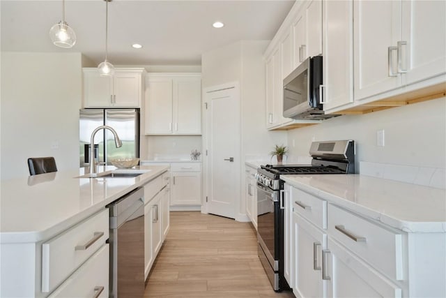 1417 Echo Ridge Ln, Marion, IA 52302 - kitchen with stainless steel appliances, light wood-style flooring, white cabinets, recessed lighting, and hanging light fixtures