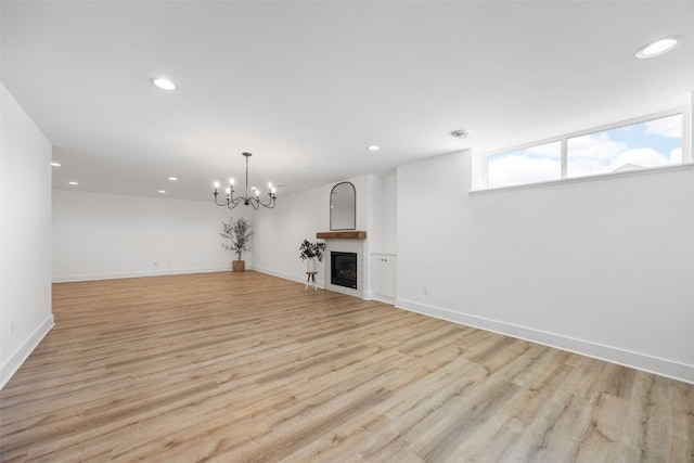 1153 Cedar Springs Dr, Marion, IA 52302 - unfurnished living room with recessed lighting, light wood finished floors, a chandelier, and a glass covered fireplace
