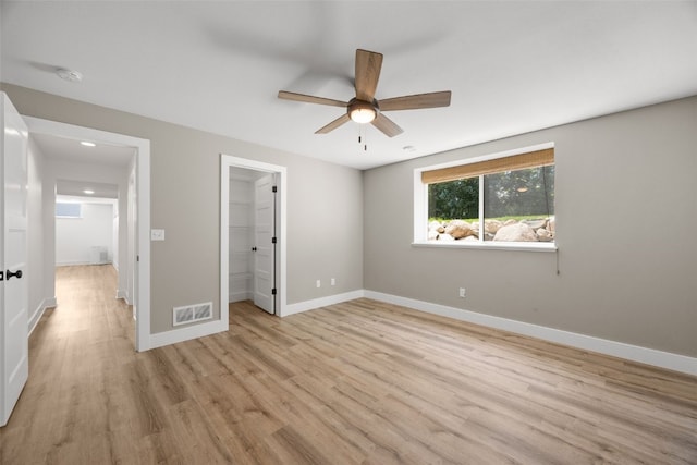 1153 Cedar Springs Dr, Marion, IA 52302 - unfurnished bedroom featuring light wood finished floors, a walk in closet, recessed lighting, ceiling fan, and a closet