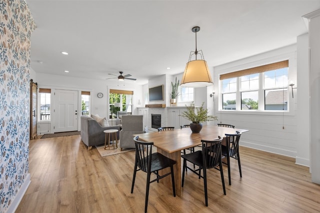 1153 Cedar Springs Dr, Marion, IA 52302 - dining room with a brick fireplace, light wood finished floors, a ceiling fan, and recessed lighting