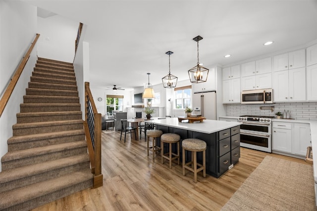 1153 Cedar Springs Dr, Marion, IA 52302 - kitchen featuring high end appliances, white cabinets, light countertops, light wood finished floors, and recessed lighting