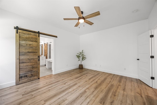 1153 Cedar Springs Dr, Marion, IA 52302 - unfurnished room with a ceiling fan, light wood-style floors, a barn door, and a smoke detector