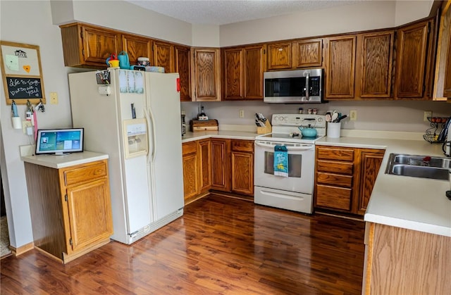 446 Bezdek Dr SW, Cedar Rapids, IA 52405 - kitchen featuring white appliances, dark wood-style floors, and brown cabinetry