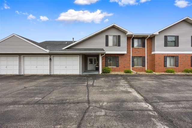 4485 Armar Dr SE Unit 101, Cedar Rapids, IA 52403 - townhome / multi-family property with brick siding, asphalt driveway, and an attached garage