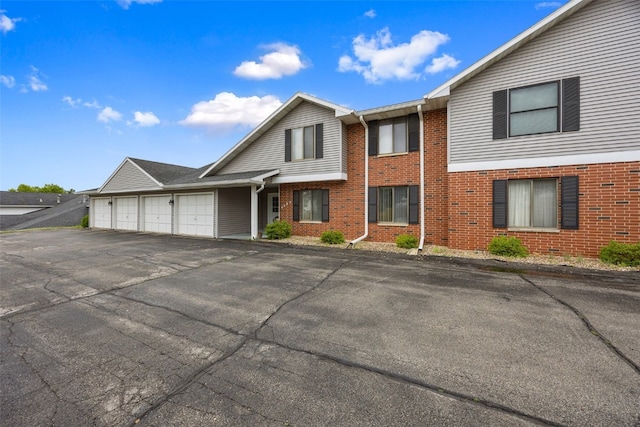4485 Armar Dr SE Unit 101, Cedar Rapids, IA 52403 - townhome / multi-family property featuring brick siding, a garage, and driveway