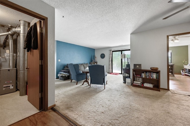 4485 Armar Dr SE Unit 101, Cedar Rapids, IA 52403 - carpeted living room with a textured ceiling, a ceiling fan, and wood finished floors