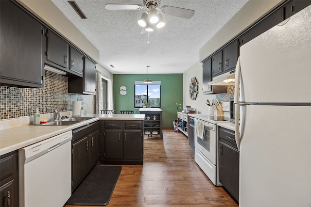 4485 Armar Dr SE Unit 101, Cedar Rapids, IA 52403 - kitchen featuring white appliances, a textured ceiling, wood finished floors, decorative backsplash, and a ceiling fan
