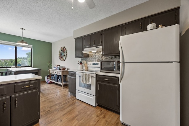 4485 Armar Dr SE Unit 101, Cedar Rapids, IA 52403 - kitchen with white appliances, under cabinet range hood, light countertops, a textured ceiling, and backsplash