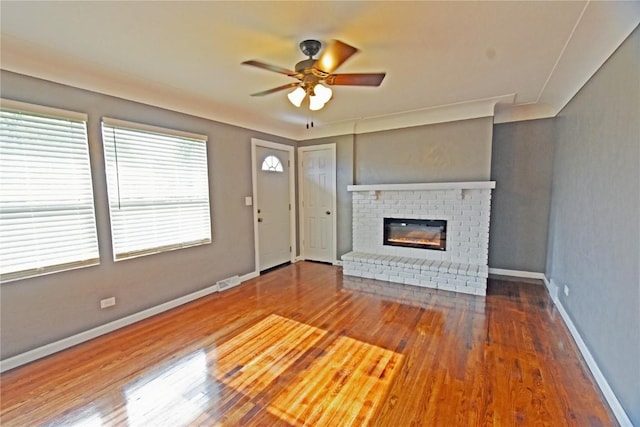 1545 26th St, Marion, IA 52302 - unfurnished living room featuring wood finished floors, a ceiling fan, and a fireplace