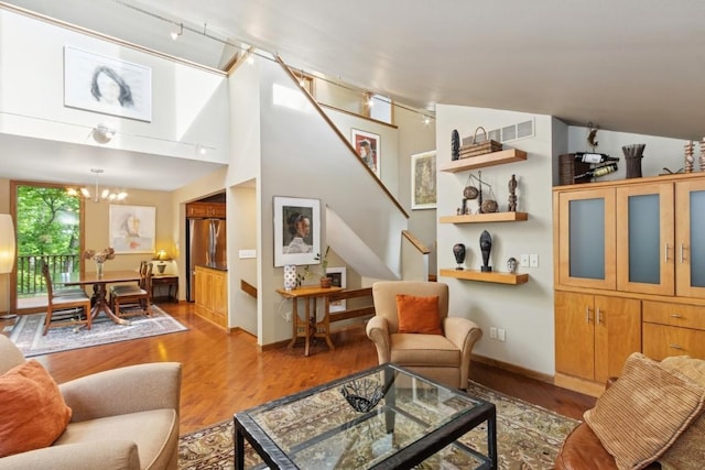 2520 NE Sugar Bottom Rd, Solon, IA 52333 - living room featuring wood finished floors, stairs, track lighting, and a chandelier
