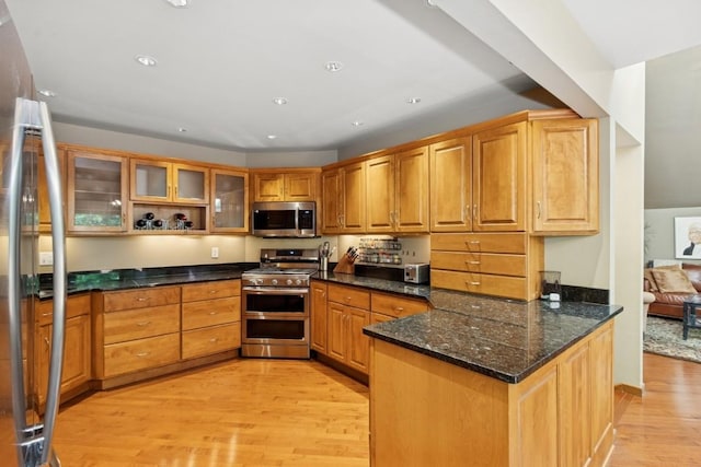 2520 NE Sugar Bottom Rd, Solon, IA 52333 - kitchen with appliances with stainless steel finishes, light wood-style flooring, a peninsula, glass insert cabinets, and dark stone counters