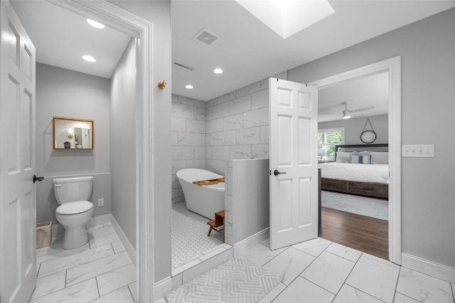 1574 Turkey Ridge Ct NW, Swisher, IA 52338 - ensuite bathroom featuring marble look tiles, a soaking tub, recessed lighting, and a ceiling fan