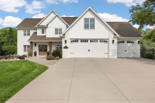 1574 Turkey Ridge Ct NW, Swisher, IA 52338 - view of front of property with driveway, french doors, brick siding, board and batten siding, and a shingled roof