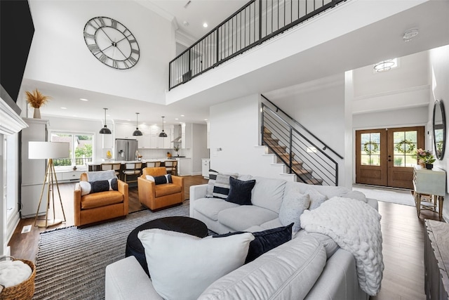 1574 Turkey Ridge Ct NW, Swisher, IA 52338 - living area with a towering ceiling, wood finished floors, plenty of natural light, stairway, and french doors