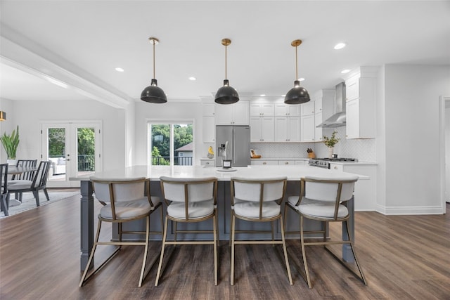 1574 Turkey Ridge Ct NW, Swisher, IA 52338 - kitchen with stainless steel fridge with ice dispenser, wall chimney range hood, white cabinets, light countertops, and dark wood-style flooring