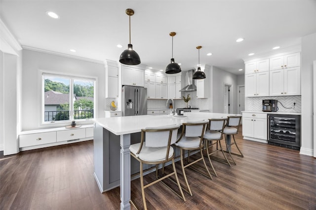 1574 Turkey Ridge Ct NW, Swisher, IA 52338 - kitchen with beverage cooler, stainless steel fridge, wall chimney exhaust hood, backsplash, and recessed lighting