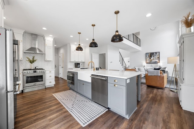 1574 Turkey Ridge Ct NW, Swisher, IA 52338 - kitchen with wall chimney range hood, stainless steel appliances, gray cabinetry, open floor plan, and backsplash