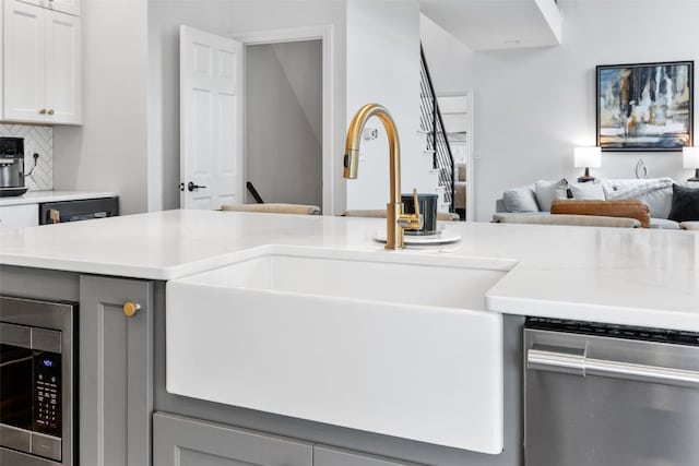 1574 Turkey Ridge Ct NW, Swisher, IA 52338 - kitchen featuring appliances with stainless steel finishes, open floor plan, tasteful backsplash, gray cabinets, and light stone countertops