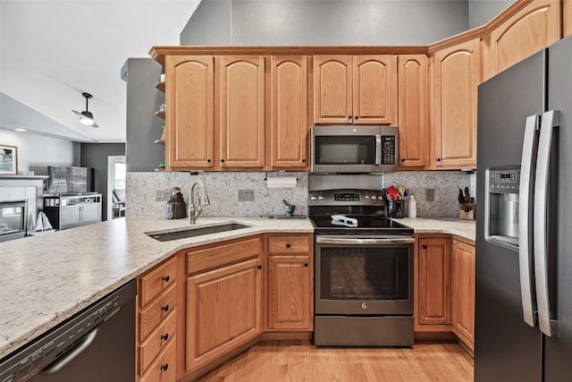 4131 Lakeview Dr SW, Cedar Rapids, IA 52404 - kitchen featuring appliances with stainless steel finishes, lofted ceiling, tasteful backsplash, light wood-type flooring, and light stone countertops