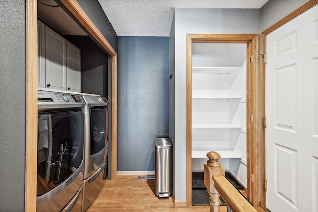 4131 Lakeview Dr SW, Cedar Rapids, IA 52404 - laundry room featuring washing machine and clothes dryer, light wood-type flooring, and cabinet space