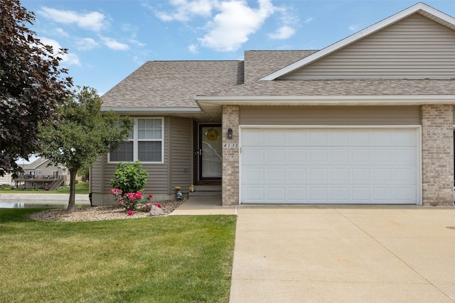 4131 Lakeview Dr SW, Cedar Rapids, IA 52404 - view of front of property featuring roof with shingles, concrete driveway, brick siding, and a front lawn
