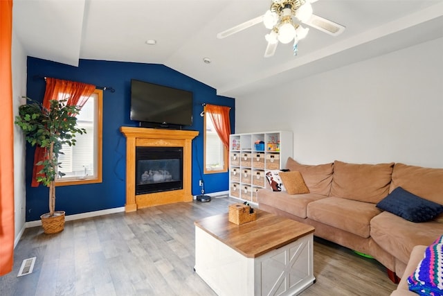 1255 Pacific St, Ely, IA 52227 - living area with a glass covered fireplace, vaulted ceiling, light wood finished floors, and a ceiling fan