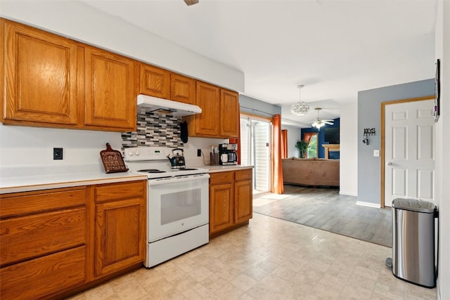 1255 Pacific St, Ely, IA 52227 - kitchen with white electric stove, under cabinet range hood, a ceiling fan, and brown cabinets