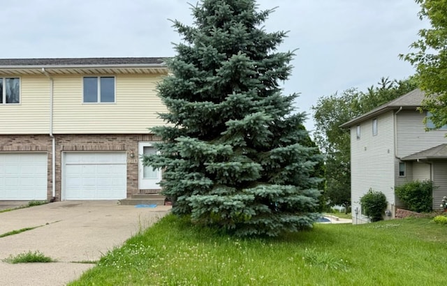 2208 Holiday Rd, Coralville, IA 52241 - view of front of property featuring an attached garage, concrete driveway, a front yard, and brick siding