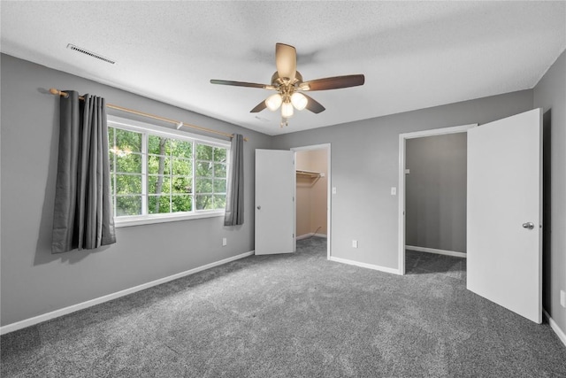 4127 Harwood Dr NE, Cedar Rapids, IA 52411 - unfurnished bedroom with carpet, a textured ceiling, a walk in closet, and ceiling fan