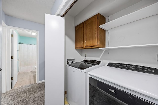 4127 Harwood Dr NE, Cedar Rapids, IA 52411 - laundry area featuring cabinet space, independent washer and dryer, light colored carpet, and light tile patterned floors