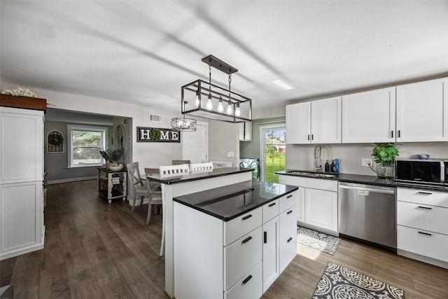 518 Main St, Fairfax, IA 52228 - kitchen featuring stainless steel dishwasher, white cabinetry, dark wood-style floors, and dark countertops
