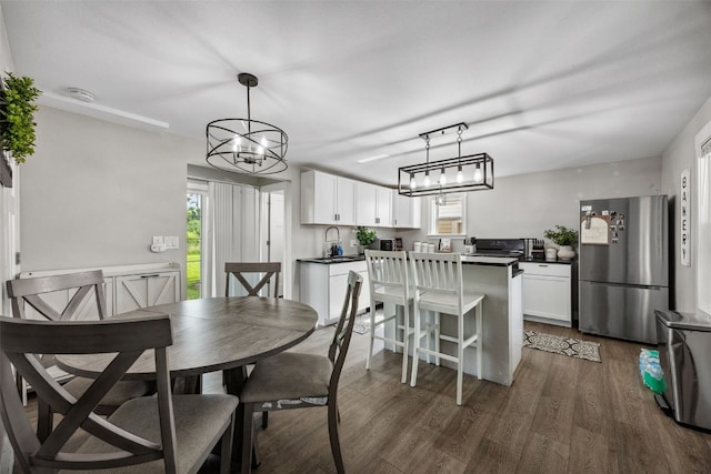 518 Main St, Fairfax, IA 52228 - dining area with a chandelier, plenty of natural light, and dark wood-type flooring