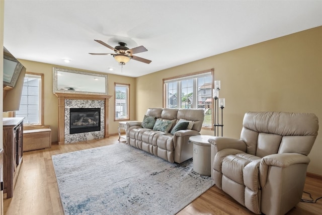 1865 Rock Island Dr, Ely, IA 52227 - living room with ceiling fan, light wood-style flooring, and a tiled fireplace