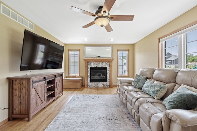 1865 Rock Island Dr, Ely, IA 52227 - living room featuring a ceiling fan, light wood finished floors, and a glass covered fireplace