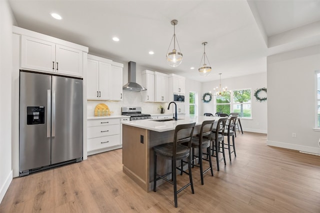 424 15th Ave SW, Mount Vernon, IA 52314 - kitchen featuring appliances with stainless steel finishes, wall chimney range hood, an island with sink, recessed lighting, and a kitchen bar