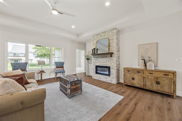 424 15th Ave SW, Mount Vernon, IA 52314 - living room with light wood finished floors, a ceiling fan, a tray ceiling, a fireplace, and recessed lighting