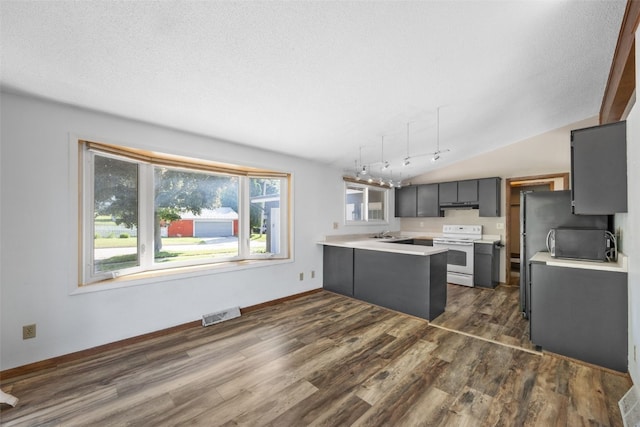212 4th St SW, Mount Vernon, IA 52314 - kitchen featuring white electric stove, a peninsula, under cabinet range hood, black microwave, and dark wood-style flooring