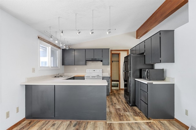 212 4th St SW, Mount Vernon, IA 52314 - kitchen with black appliances, under cabinet range hood, a peninsula, lofted ceiling, and wood finished floors